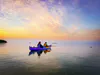 A tandem sea kayak enjoys a sunrise on calm Lake Huron in the Les Cheneaux Islands.