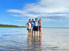 A family stands in the waters of Lake Huron during their Perfect Overnight kayaking trip in the Les Cheneaux Islands.